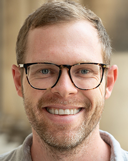 photo of smiling male with blond hair and glasses